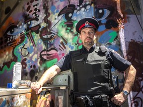 Const. Steve Koopman stands in front of some of the graffiti found behind the Grand Theatre in downtown Kingston. 
Sam Koebrich for The Whig-Standard