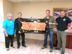 Betty James (far left) and Jason Reynolds (far right) presented the artwork shown to the Fairview Fire Department to commemorate the new firehall, opened Nov. 2012. Captain Kerry Cleave (left) and Firechief Garry Leathem hold the art.