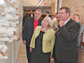 Ontario Health Minister Deb Matthews looks at an art installation as she tours the Grand River Community Health Centre on Colborne Street during its grand opening on Wednesday.  With her are Brantford MPP Dave Levac (left) and Peter Szota, the centre's executive director. (Brian Thompson, The Expositor)