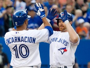 Blue Jays first baseman Adam Lind is congratulated by teammate Edwin Encarnacion after hitting a home run against the Rockies at the Rogers Centre in Toronto, June 19, 2013. (FRED THORNHILL/Reuters)
