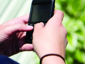 A city student checks her messages on a cell phone Wednesday morning. The Upper Canada District School Board passed policy allowing students the right to have the such devices in the classroom (THOMAS LEE/The Recorder and Times).