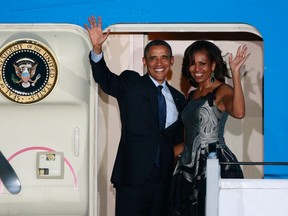 U.S. President Barack Obama, left, and First Lady Michelle wave as they board Air Force One to depart from Berlin June 19, 2013. (REUTERS/Thomas Peter)
