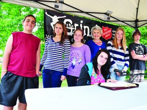 RYAN PAULSEN   Destany Aubrey, seated, prepares for her first leg of The Grind Youth Centre's portion of the Public Bible Reading event, joined by her fellow readers Codie Jones, left, Storm Bastien, Julia Phannenhour, event co-ordinator Rev. Ana Beck, Katie Barr and Bryce Pynn. The youth group, the first non-congregational gathering to tackle part of the project, spent two hours of a recent Saturday afternoon reading through the book of Proverbs in the parking lot of the Pembroke Salvation Army.