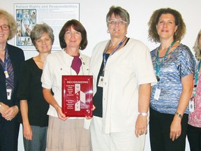 Posing with the quality award given by the South West LHIN to GBHS for its Home First program, are, from left to right: GBHS president and CEO Maureen Solecki, GBHS social worker Michelle Moreau, GBHS manager Robin Dykeman, GBHS senior director of rural health care and chronic diseases Elaine Burns, interim client service manager of the CCAC Vicki Gingrich, and CCAC nurse Kerry Cragg. Tracey Richardson photo.
