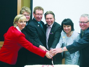 Members of the Alberta Industrial Heartland Association cut a cake to celebrate the 15-year anniversary of the association. Photo by Aaron Taylor.