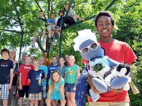 John Hazika, 11, holds Mandela, right, the Mr. Nobody doll the Mrs. Marianne Visser's Grade 6 students, background, at Chatham Christian School have dressed with items representing the community impact projects the students initiated throughout the school year. PHOTO TAKEN Chatham, On., Thursday June 20, 2013. DIANA MARTIN/ THE CHATHAM DAILY NEWS/ QMI AGENCY