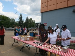 YMCA Housing First coordinator Alexia Tjongaero, Darlene Rose Auger and Dave Moore grab some food at a free barbecue downtown Thursday. ANDREW BATES/TODAY STAFF