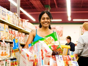 Const. Shannon Neff smiles after dumping cereal into her cart during Portage Co-op's 3rd annual Cooper Marketplace Sweep on Friday. Neff had to collect as many groceries as she could in 90 seconds. She will donate the cereal to the Portage la Prairie School District breakfast program. (Svjetlana Mlinarevic/Portage Daily Graphic/QMI Agency)