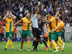 Australia's Matthew Mckay is given a yellow card as Japan is awarded a penalty kick during their 2014 World Cup qualifying soccer match in Saitama, north of Tokyo, June 4, 2013. (Yuya Shino/Reuters)