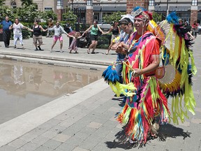 Six Nations dancers Tony Johnson and Christina Hill-Harris lead people in a round dance on Friday, June 21, 2013 around the splash pad at Harmony Square, marking Aboriginal Day in Brantford. (BRIAN THOMPSON Brantford Expositor)