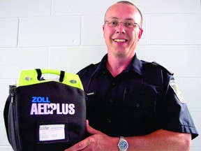 Brockville Police Service Sergeant Todd Bertrend holds up a defibrillator, a device used to save people suffering from a heart attack. The city police force will soon have four vehicles equipped with defibrillators (THOMAS LEE/The Recorder and Times).