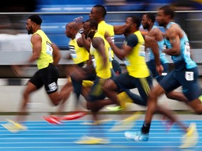 Tyson Gay of the U.S. (L) leads the field winning his men's 100 meters semi-final heat at the Diamond League Adidas Grand Prix in New York, May 25, 2013. (REUTERS/Gary Hershorn)