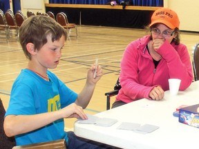 Ryan McCartney, 9, demonstrates Friday afternoon a card trick to his mom Linda McCartney at the Cultural-Recreational Centre, where an evacuation centre was set up for people affected by floods. The family, which included brother Jamie Peterson, 11, fled their home in High River. Linda, who purchased a house in High River in 1976 in a part of the town that had never flooded before, said she’s never seen the kind of devastation brought on by the floods.
Simon Ducatel Vulcan Advocate