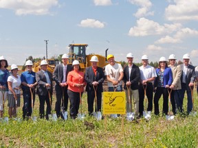 A yellow-helmeted Dr. Philip J. Currie (centre) stands proudly with major stakeholders, donors and volunteers of the Philip J. Currie Dinosaur Museum before breaking into the ground on Friday June 21, 2013. The sod-turning took place at the museum's future site in Wembley, marking the start of construction on the $35-million project. The facility should be complete by summer 2014 and include three levels and a 64-seat theatre. ELIZABETH McSHEFFREY/HERALD-TRIBUNE/QMI AGENCY