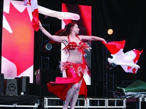 Today file photo
Waving a pair of Canadian flags, Karen Savoie of the Fort McMurray Belly Dance Academy performs at last year’s MacIsland’s Canada Day Barbecue.