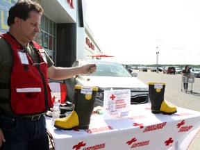 Tim Trevenna was among the local volunteers tightening their bootstraps for the Canadian Red Cross setting up shop at different locations around town to raise money for the local disaster management fund. Saturday's Boot Drive fundraiser was the first of its kind in Timmins, with all proceeds staying in town.

Photo taken on Saturday, June 22, 2013 in Timmins. BENJAMIN AUBÉ/THE TIMMINS DAILY PRESS/QMI AGENCY