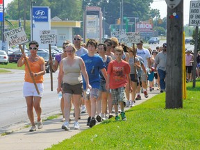Jennifer Corsini of Simcoe, in the orange shirt, led a victims’ rights march down the Queensway East in Simcoe Sunday morning. About 70 supporters joined her. Corsini nearly died five years ago after being attacked by her estranged husband in Turkey Point. (MONTE SONNENBERG Simcoe Reformer)