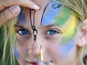 Amanda Knelsen has her face painted by Cynthia Brink during the Frogmore Summer Kick-Off Picnic Sunday, combined this year with the grand opening of Frogmore's new community park. CHRIS ABBOTT/TILLSONBURG NEWS