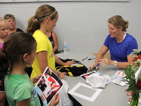 Four-time Olympic medalist and women's hockey ambassador Hayley Wickenheiser signs autographs at the Point Edward Arena, Sunday. Wickenheiser met with local youth, including members of the Sarnia Junior Lady Sting Atom C team, who won the provincial championships last year, coached by Erin White. The visit was the result of a winning contest entry from teammate Tori Iacobelli. (TARA JEFFREY, The Observer)