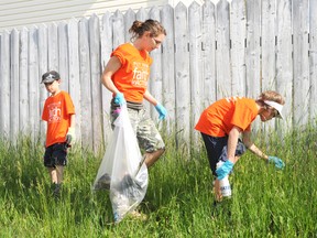 Elizabeth McSheffrey/Daily Herald-Tribune
Westpointe Community Church members Jennifer Schroeder and her two sons Micah, 7, and Caleb, 9,  prowl for garbage along 94 Street and 108 Avenue during a Hillside community clean-up on Sunday. The six-hour scrub brought in piles of garbage, mowed dozens of lawns and recycled old waste in support of city solidarity and going green.
