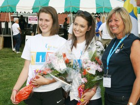 Starting out by organizing a relay for life team when they were students at Harris Heights Public School, Maggie Carter and Naomi Hopson have been volunteers with the Canadian Cancer Society Relay for Life in Ingersoll for five years. Their contributions and those of Ingersoll relay founders Dan St. Amand, Ann Campbell and Wayne Campbell were recognized during opening ceremonies for the 11th annual Ingersoll relay on Friday, June 21, 2013. Ingersoll relay co-chair Jo-Ann Thibideau presented the five honourees with flowers.