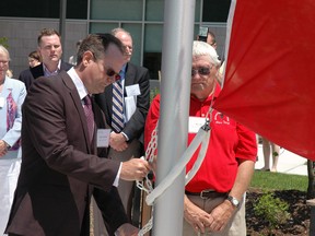 Former patients Brett Batten and Bill Lee raise a flag Friday during the official opening of the new Southwest Centre for Forensic Mental Health in St. Thomas.