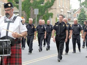 Led by a drummer of the Ontario Fire Service Pipes and Drums, Sebringville's firefighters parade through the centre of the village Saturday in celebration of the local station's 50th anniversary. DONAL O'CONNOR / The Beacon Herald