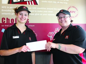 KFC manager Shalon Thir, right, presents the scholarship to Jessica Schaub.