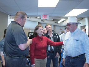 Premier Alison Redford discusses the evacuation centre needs with Nanton Mayor John Blake and director of energency services George Woof on June 22.