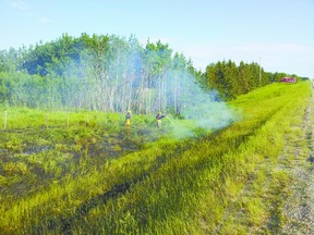 Mayerthorpe firefighters work to put out this grass fire in Lac Ste. Anne County on Highway 22 about seven miles south of town.