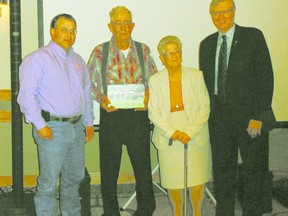 Graham Sharp, left, Alberta Shorthorn Association, vice-president, and Verlyn Olson, right, Minister of Agriculture and Rural Development, present the Canadian Shorthorn Association Legends of the Breed award to Leonard Greenwood, Dorothy Greenwood.