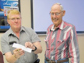 John Heaven, right, president of the Mayerthorpe Ag Society, sells the first raffle ticket for the society’s fundraiser to Mayerthorpe Mayor Kim Connell on Monday, June 17, before the 7 p.m. council policies and priorities meeting at the Mayerthorpe town hall.