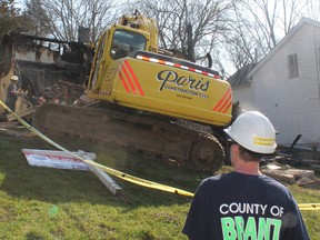 An earth mover demolishes a house gutted by fire on West River Street in Paris, Ontario in late March 2012, leaving a family homeless. The house wasn't insured, but the family was helped by the community to get back on their feet. (MICHAEL PEELING QMI Agency)