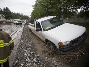 A pickup truck remains stuck in the mud on Monday, June 24, 2013 after the Hamlet of Exshaw was hit hard by floodwaters. Justin Parsons/ Canmore Leader/ QMI Agency