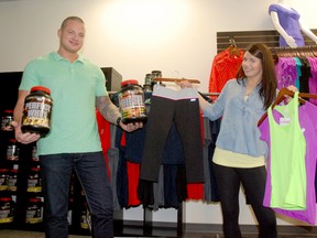 Garrett Buchanan, left, owner of Believe Fit, and store manager Stephanie Jackman, go through some of the clothing and fitness products available at the new fitness apparel store located on 104A Avenue. (Jocelyn Turner/Daily Herald-Tribune)