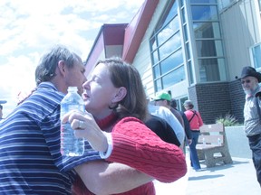 Town of High River Mayor Emile Blokland gets a hug of support from Alberta Premier Alison Redford