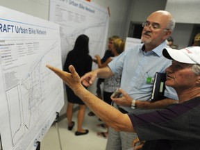 IBI Group Senior Associate Don Drackley, left, discusses proposed bike lanes in Sarnia with Bluewater Trails committee member Tony Barrand at an open house at Clearwater Arena Tuesday. IBI consultants were looking for public feedback on a draft master transportation and transit plan for the city. (TYLER KULA, The Observer)