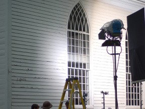 Crews adjusting lighting rigs outside Christ Church at Upper Canada Village, where the film Tell the World is currently being shot.