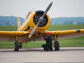 Service crew member Shawn Newman wipes down a Harvard airplane at St. Thomas Municipal Airport. The plane is part of the Harvard Aircraft Formation Team, slated to appear at the Great Lakes International Airshow. Ben Forrest/QMI Agency/Times-Journal