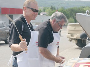 Terry Babiy and Jim Tallman fry burgers for the masses at Royal LePage Casey Realty on Friday June 21 to celebrate Royal Lepage's100th anniversary.