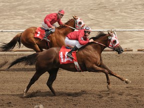 Jockey Nate Smith on the quarterhorse Pow Wow Lane (1A) and jockey Craig Wonnacott on horse Fast Fifty (1) fly along the track  during a race at the Horses at Evergreen Park last July. The races kick off this summer on July 5. (DHT file photo)