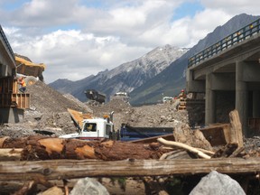 Crews work to fix the Trans-Canada Highway at the Highway 1A crossing in Canmore on Wednesday, June 26, 2013. The TCH opened Wednesday afternoon to one-lane traffic in each direction. Highway 1A remained closed in Canmore to non-emergency traffic. Dave Husdal/ For the Leader