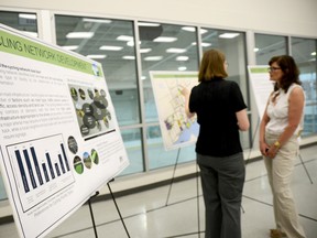 Visitors to an open house regarding the city's transportation system discuss issues regarding cyclists and a proposed cycling network in the city.