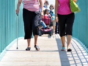 Rosie Baert, left, and Joyce Hensel, stroll across the Stonehouse pedestrian bridge slated for divestment in  Wallaceburg. A grassroots group of concerned citizens spent 12 hours Wednesday recording the number of people who use the bridge on a daily, weekly and monthly basis in the hopes the numbers will encourage the Municipality of Chatham-Kent to invest in maintaining the walkway over the Sydenham River. (DIANA MARTIN, The Daily News)