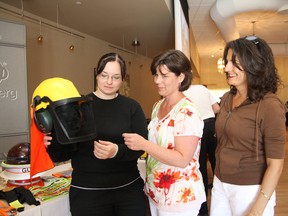 Ashley Smith, left, Cori-Lynn Lemaitre and Suzanne Sardinha examine a safety hard hat at a Women in Trades expo in Sudbury, ON. on Wednesday, June 26, 2013. The trade show was presented by CenturyVallen. JOHN LAPPA/THE SUDBURY STAR/QMI AGENCY