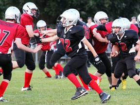 Ethan Pierce of the Woodstock Wolverines black team follows blockers into the gap in the red team's line during their June 21, 2013 game at College Avenue Secondary School. The Woodstock Minor Football Association's tackle program will play their final game of the season Friday night at CASS starting at 7 p.m. (GREG COLGAN, Sentinel-Review)