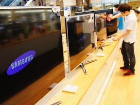 An employee wipes the surface of Electronics Smart TV at a Samsung Electronics store in the company's main office building in Seoul July 27, 2012. (REUTERS/Kim Hong-Ji)