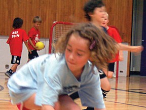 Children grab sponge balls before retreating back onto their half of the gym during a game of dodgeball at the Summer Sports Camp run by Trevor Belrose at Beaver Brae Secondary School. 
GRACE PROTOPAPAS/KENORA DAILY MINER AND NEWS/QMI AGENCY