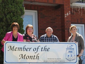 Laura Labelle (far left) and Julia Martin (far right) from the Board of Trade present Bernie Brydle and her husband Richard Brydle with the Member of the Month banner for Bernie's business Brydle Bookkeeping and Income Tax Services.