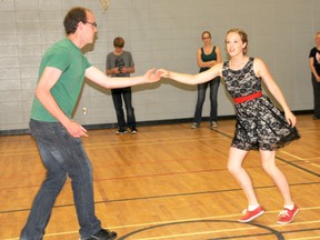 Flat City Swing founder Leah Granger and dance partner Taylor Gill (centre) get groovy during a beginner’s swing lesson at Harry Balfour School on June 22. The pair starts each bi-monthly gig with instruction for newcomers and ends it with a free-for-all dance party. (Elizabeth McSheffrey/Daily Herald-Tribune)